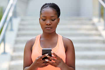 Image showing sporty african woman using smartphone in city