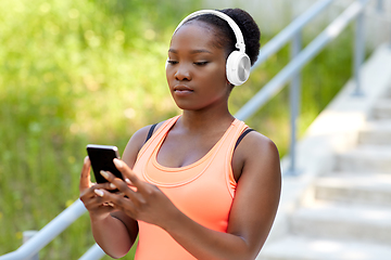 Image showing african american woman with headphones and phone