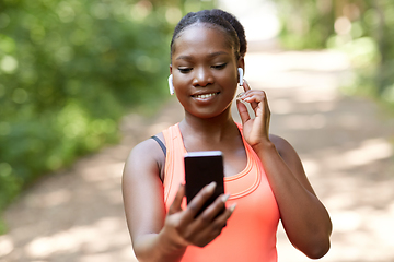 Image showing african american woman with earphones and phone