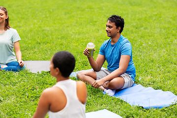 Image showing group of people sitting on yoga mats at park