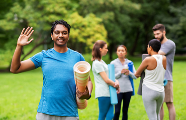 Image showing smiling man with yoga mat over group of people