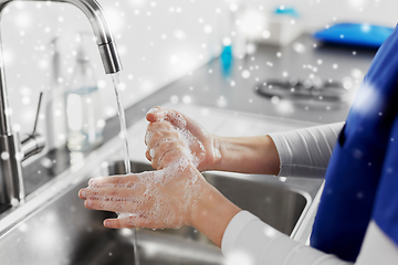 Image showing doctor or nurse washing hands with liquid soap