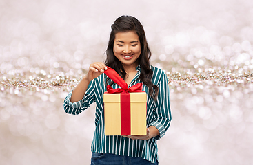 Image showing happy asian woman opening gift box