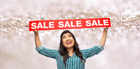 Image showing happy smiling young asian woman with sale banner