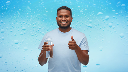 Image showing happy african man with water in glass bottle