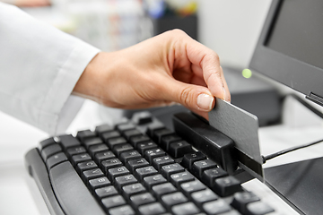 Image showing close up of pharmacist's hand swiping credit card