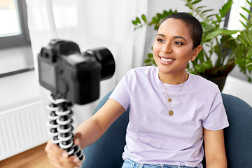 Image showing female blogger with camera video blogging at home