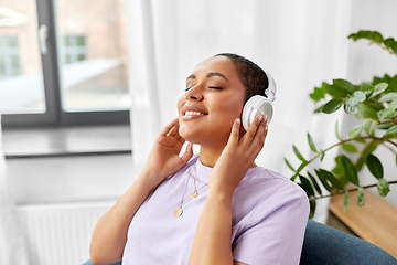 Image showing woman in headphones listening to music at home