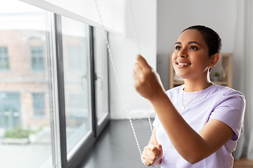 Image showing woman opening window roller blinds