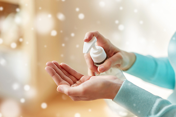 Image showing close up of woman applying hand sanitizer