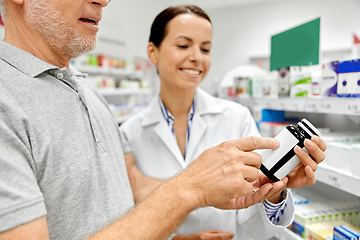 Image showing pharmacist and old man with medicine at pharmacy