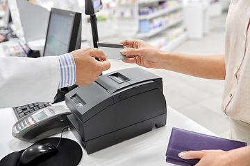 Image showing close up of hand giving bank card to pharmacist