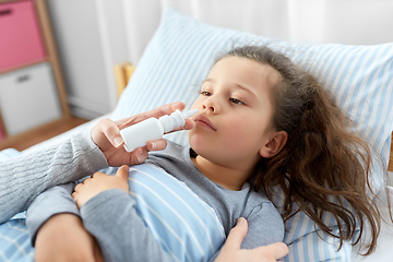 Image showing mother with nasal spray treats sick daughter