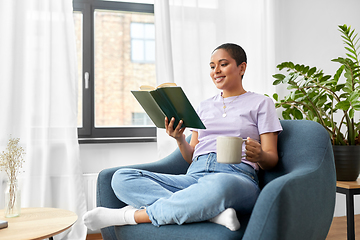 Image showing happy african american woman reading book at home