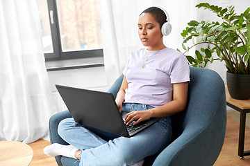 Image showing woman with laptop listening to music at home