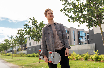 Image showing teenage boy with skateboard on city street