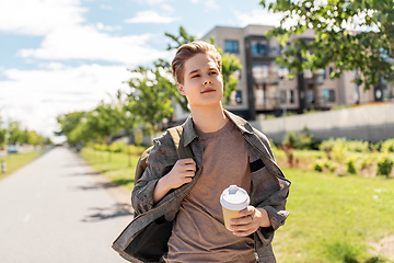 Image showing young man with backpack drinking coffee in city