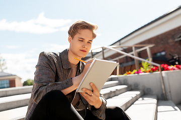 Image showing young man with notebook or sketchbook in city