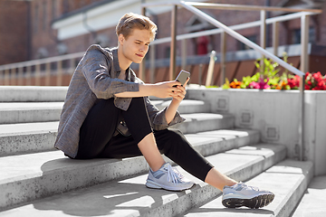 Image showing teenage boy using smartphone in city