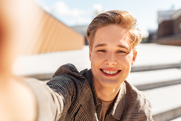 Image showing young man or teenage boy taking selfie in city