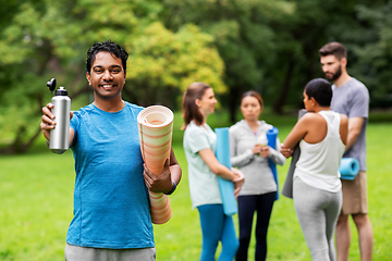 Image showing happy man with bottle over people meeting for yoga