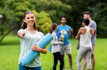 Image showing woman with yoga mat pointing finger to camera