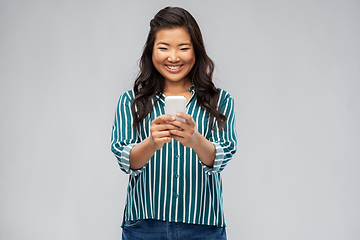 Image showing happy asian woman using smartphone