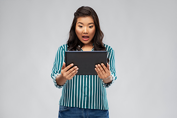 Image showing surprised asian woman using tablet computer