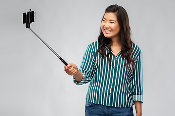 Image showing happy asian woman taking selfie with smartphone