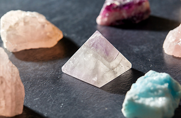 Image showing quartz crystal pyramid and gem stones on slate