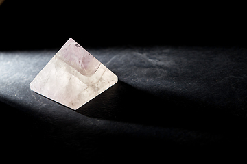 Image showing quartz crystal pyramid on slate stone in darkness