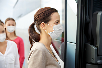 Image showing group of passengers in masks boarding travel bus