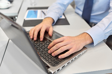 Image showing close up of businessman with laptop at office