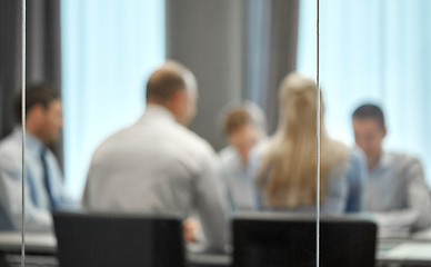 Image showing business team meeting at office behind glass wall