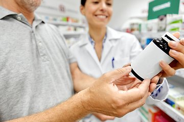 Image showing pharmacist and old man with medicine at pharmacy