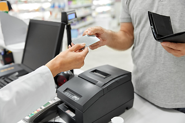 Image showing close up of hand giving bank card to pharmacist