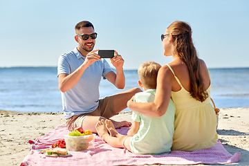 Image showing family with smartphone photographing on beach