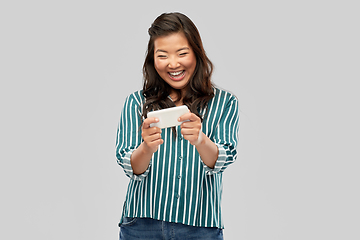 Image showing happy asian woman using smartphone