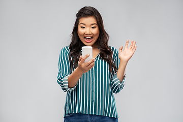 Image showing happy asian woman with smartphone waving hand
