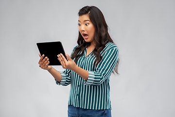 Image showing shocked asian woman using tablet computer