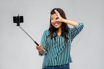 Image showing happy asian woman taking selfie with smartphone