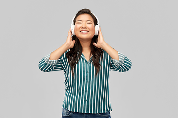 Image showing asian woman in headphones listening to music