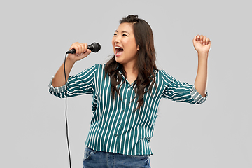 Image showing happy asian woman with microphone singing