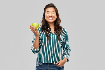 Image showing happy smiling asian woman holding green apple