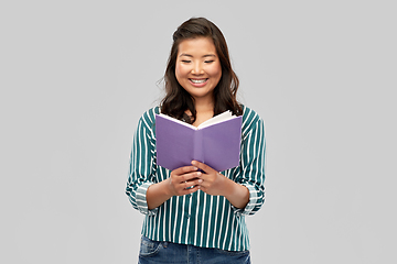 Image showing happy asian woman reading book