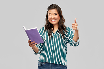 Image showing happy asian woman with book showing thumbs up