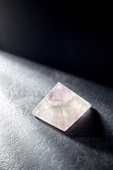 Image showing quartz crystal pyramid on slate stone in darkness