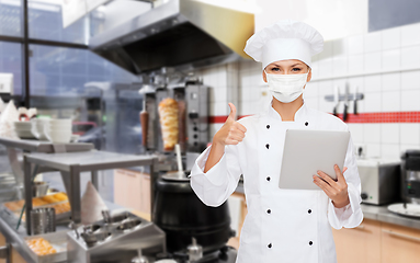 Image showing female chef in mask with tablet pc at kitchen