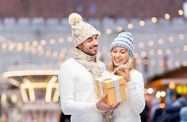 Image showing smiling couple in winter clothes with gift box