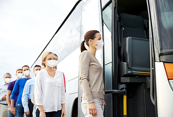 Image showing group of passengers in masks boarding travel bus